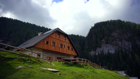 Footage-filmed-of-a-big-house-surrounded-by-mountains-in-nature-up-in-the-alps,-filmed-with-a-camera-on-a-gimble-in-4k
