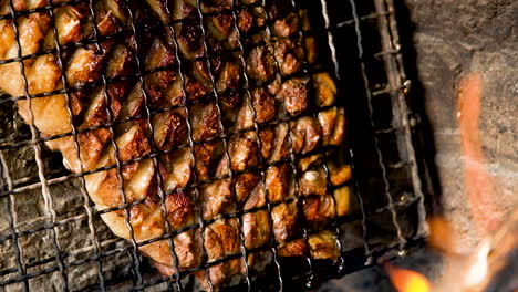 Juicy-lamb-rib-being-barbecued-till-crispy,-fat-dripping,-heat-from-open-fire