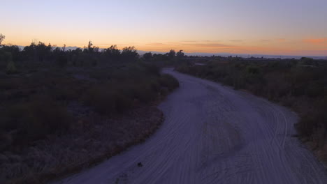 Flying-over-a-dry-riverbed-due-to-drought-caused-by-climate-change-in-California's-Central-Valley-at-sunrise