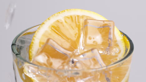 Kaltes,-Frisches-Sprudelwasser,-Das-Mit-Eis-Und-Zitronenscheiben-In-Ein-Glas-Gegossen-Wird-2