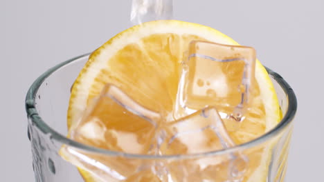 Kaltes,-Frisches-Sprudelwasser,-Das-Mit-Eis-Und-Zitronenscheiben-In-Ein-Glas-Gegossen-Wird-1