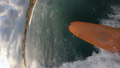 Man-surfing-on-ocean-wave-on-surfboard-on-tropical-beach,-POV-vertical