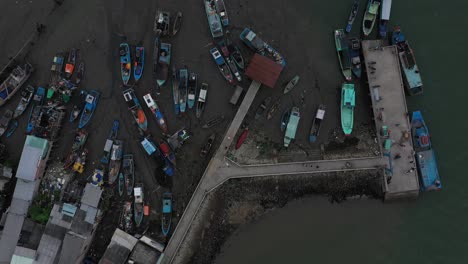 Aerial-top-down-rotation-view-of-fishing-boats-and-ferry-wharf-at-low-tide-Can-Gio-Vietnam