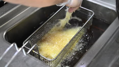 Frying-the-thin-slices-of-potatoes-in-an-automatic-fryer,-preparation-of-Turkish-kebab