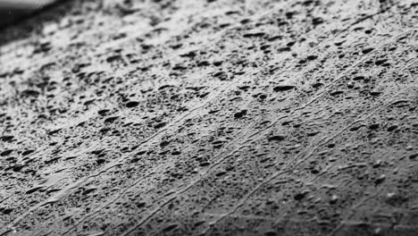 Close-up-footage-of-raindrops-rolling-down-a-car-window-during-a-rainstorm