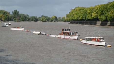 Luxury-Boats-On-The-Thames-Within-Putney-In-Front-Of-Fulham-Stadium,-London,-United-Kingdom