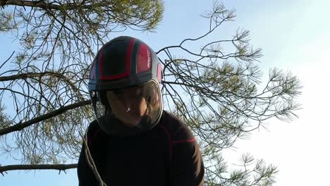 Lower-angle-of-a-30-years-old-woman-wearing-a-helmet-with-a-transparent-visor,-special-for-chainsawing