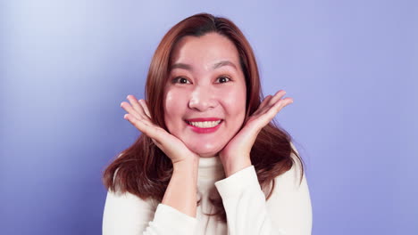 Portrait-of-young-Asian-lady-with-a-positive-expression,-joyful-surprise-funky-and-looking-at-camera-over-violet-background-1