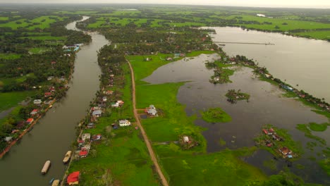 Aerial-view-revealing-tropical-green-and-rural-landscape-of-Kumarakom-river,-Kerala