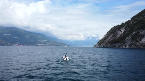 Drone-shot-boat-sailing-on-lake-in-mountain-valley