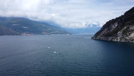 Boats-sailing-and-cruising-on-Lake-Como-water-with-beautiful-mountains