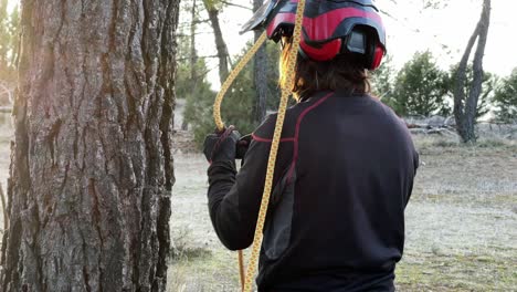 Woman-worker-unties-rope-in-forest-for-high-altitude-pruning