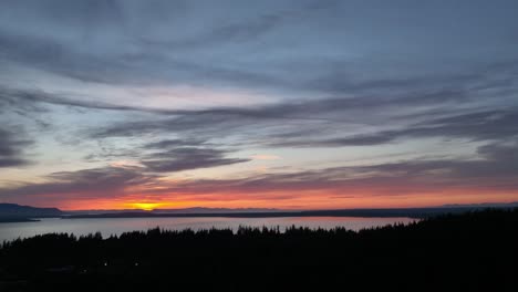 Aerial-shot-of-the-Sehome-Hill-Arboretum-forest-overlooking-the-sunset-over-Bellingham-Bay