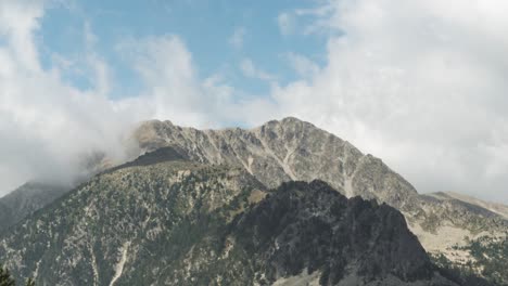 Fluffy-White-Clouds-Passing-Over-The-Pyrenees-Mountain-Peak-At-Daytime-In-Andorra,-Spain