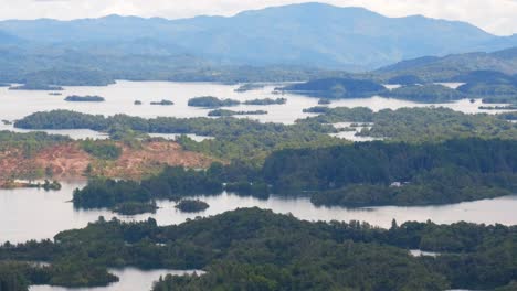 Magnificent-Aerial-Drone-flying-over-Islets,-Lake-and-Hills-of-Guatape-Medellin-Colombia