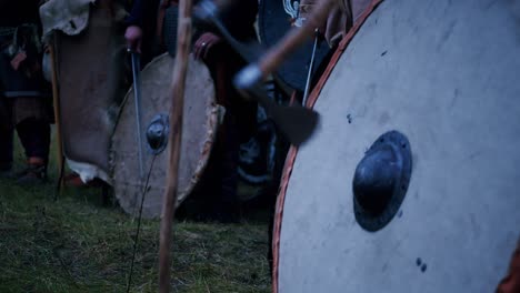 Vikingos-Golpeando-El-Escudo-Con-Espadas-Y-Hachas-Antes-De-La-Batalla-Al-Atardecer-En-Cámara-Lenta