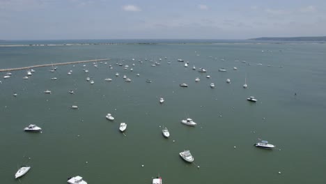 Hyperlapse-drone-shot-of-clouds-moving-over-moored-boats,-in-sunny-Plymouth,-USA