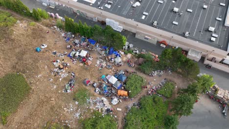 Aerial-shot-rising-above-a-homeless-camp-to-reveal-how-close-it-is-to-major-shopping-facilities