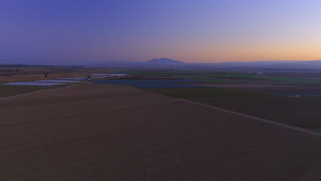Twilight-over-farmland-fields-in-California's-Central-Valley-near-King-City---hazy-sunset-dusk-aerial-flyover