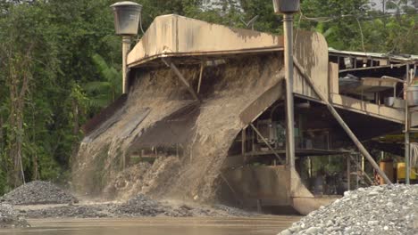 Processed-sand-and-mud-spewing-out-of-a-gold-dredger-in-to-the-river-in-Checo,-Colombia-2