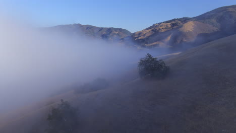 Low-valley-fog-in-the-hills-and-mountain-on-a-Southern-California-morning---aerial-flyover