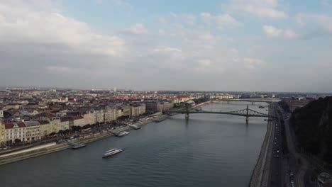 Donaubio-Quer-Durch-Budapest-Stadt-Bei-Einem-Trüben-Sonnenuntergang-über-Der-Brücke