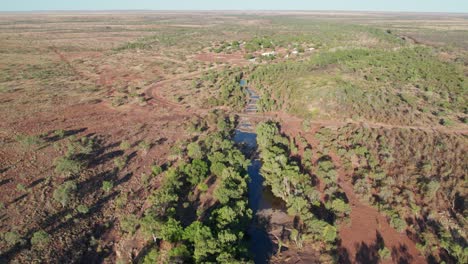 Aerial-footage-over-waterholes-in-the-Wattie-Creek-with-the-community-of-Daguragu-in-the-background,-Northern-Territory,-Australia