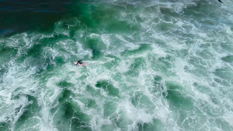 Girl-surfer-swims-through-white-water