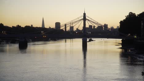 Die-Skyline-Von-London-Im-Morgengrauen-Spiegelt-Sich-In-Der-Themse-Mit-Albert-Bridge-Und-Battersea-Bank-4k-Wider
