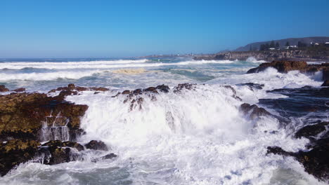 Angry-ocean-waves-thrashing-jagged-shoreline-in-Hermanus,-South-Africa