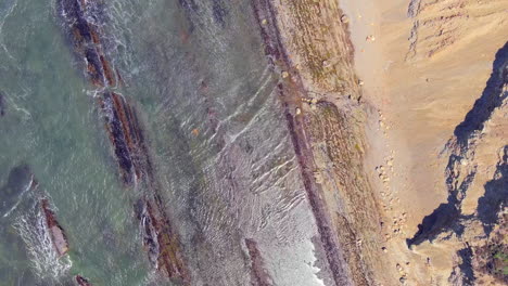 Luftaufnahme-Der-Wellen,-Die-Am-RCA-Beach-In-Zentralkalifornien-Entlang-Der-Sandsteinfelsen-An-Land-Gespült-Werden