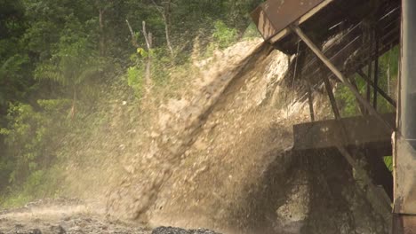 Processed-sand-and-mud-spewing-out-of-a-gold-dredger-in-to-the-river-in-Checo,-Colombia-1