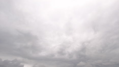 Statische-Aufnahme-Von-Grauen-Wolken,-Die-Sich-Langsam-Durch-Den-Hellen-Himmel-Bewegen
