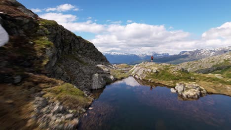 Drohne,-Die-über-Ein-Malerisches,-Spiegelndes-Gletscherwasser-Auf-Der-Spitze-Des-Hardangervidda-bergplateaus-Fliegt,-Endet-Mit-Der-Enthüllung-Des-Ikonischen-Norwegischen-Sees-Und-Der-Schneebedeckten-Berge-Im-Hintergrund