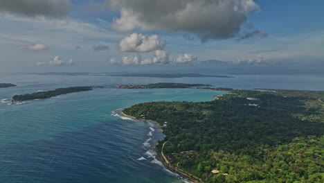 Bocas-del-Toro-Panama-Aerial-v7-cinematic-reverse-flyover-capturing-paunch-beach,-beautiful-island-seascape-and-lush-green-natural-reserve-on-a-idyllic-spring-day---Shot-with-Mavic-3-Cine---April-2022
