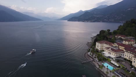 Barcos-Que-Navegan-Por-El-Lago-De-Como-Pasando-Por-Hoteles-Históricos-En-Bellagio,-Lombardía,-Italia