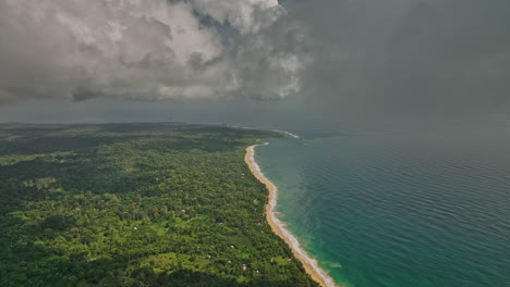 Bocas-del-Toro-Panama-Aerial-v8-cinematic-flyover-capturing-bluff-beach,-turquoise-sea-water-and-dense-lush-green-vegetation-with-thick-tropical-clouds-in-the-sky---Shot-with-Mavic-3-Cine---April-2022