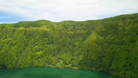 Aerial-view-of-vertical-volcanic-hill-of-tropical-forest-in-the-crater-of-Sete-Cidades