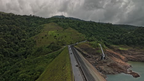 Hornito-Panama-Aerial-V1-Cinematic-Flying-Direkt-über-Der-Straße-Des-Staudamms-Mit-Fahrzeugen,-Die-über-Die-Landschaft-Fahren-Und-Den-Wunderschönen-Fortuna-Stausee-Einfangen-–-Aufgenommen-Mit-Mavic-3-Cine-–-April-2022