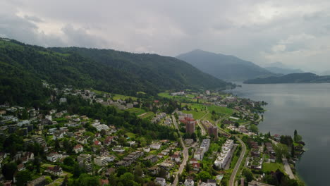 Vuelo-Sobre-Zug-En-Suiza-Con-Montañas-Y-Lago-Al-Fondo