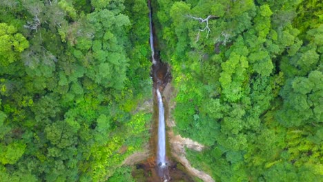 Static-aerial-view-of-tall-waterfall-in-the-jungle-of-Sao-Miguel-forest,-Azores