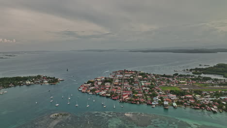 Bocas-del-Toro-Panama-Aerial-v16-cinematic-birds-eye-view-flyover-bay-island,-tilt-up-capturing-town-with-airport-runway-and-beautiful-seascape-of-caribbean-sea---Shot-with-Mavic-3-Cine---April-2022