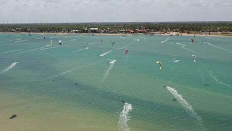 Many-kite-surfers-on-the-water-at-Ilha-do-Guajiru,-Brazil,-drone-view