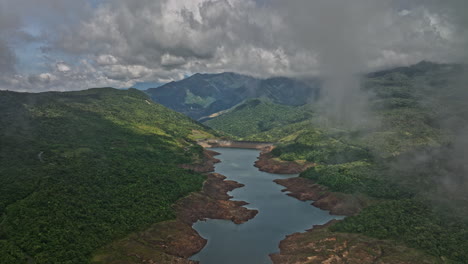Hornito-Panama-Aerial-v5-cinematic-transitioning-shot,-drone-fly-through-thick-clouds-reveals-fortuna-reservoir-and-hillside-vegetations-and-natural-landscape---Shot-with-Mavic-3-Cine---April-2022