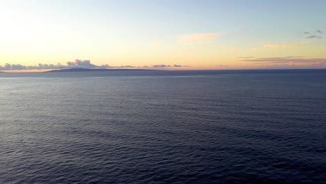 Scenic-sunset-aerial-view-over-calm-ocean,-panoramic-vista-of-Hawaiian-island-on-horizon-with-vibrant-sky