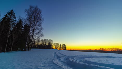 Zeitraffer-Des-Lebendigen-Sonnenuntergangs-Im-Horizont-Des-Nordischen-Schneefeldwaldes,-Magische-Farben