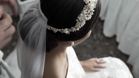 Decorating-the-bride-diadem-with-a-white,-thin-cloth,-close-up-view-from-above
