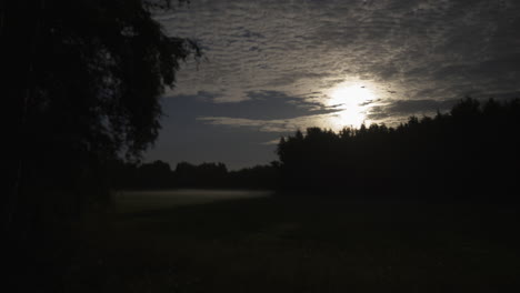 Cinematic-mood,-Full-moon-time-lapse-as-blanket-of-cloud-sheet-moves-over-rural-countryside-meadow