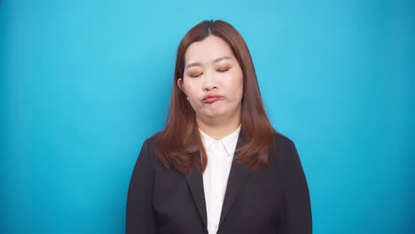 Frustrierte-Gestresste-Junge-Asiatische-Geschäftsfrau,-Die-Mit-Emotionen-Der-Enttäuschung-Fertig-Wird,-Die-über-Einem-Blauen-Hintergrund-Isoliert-Sind