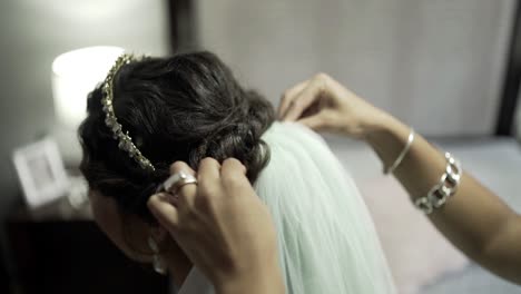 Adjusting-a-white,-thin-cloth-on-the-hair-of-the-bride-just-before-the-wedding